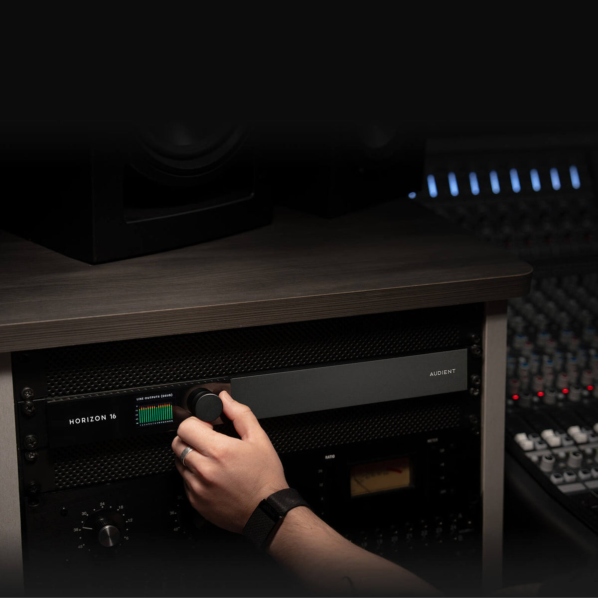 Hand adjusting the Audient Horizon 16 monitor control in a studio rack